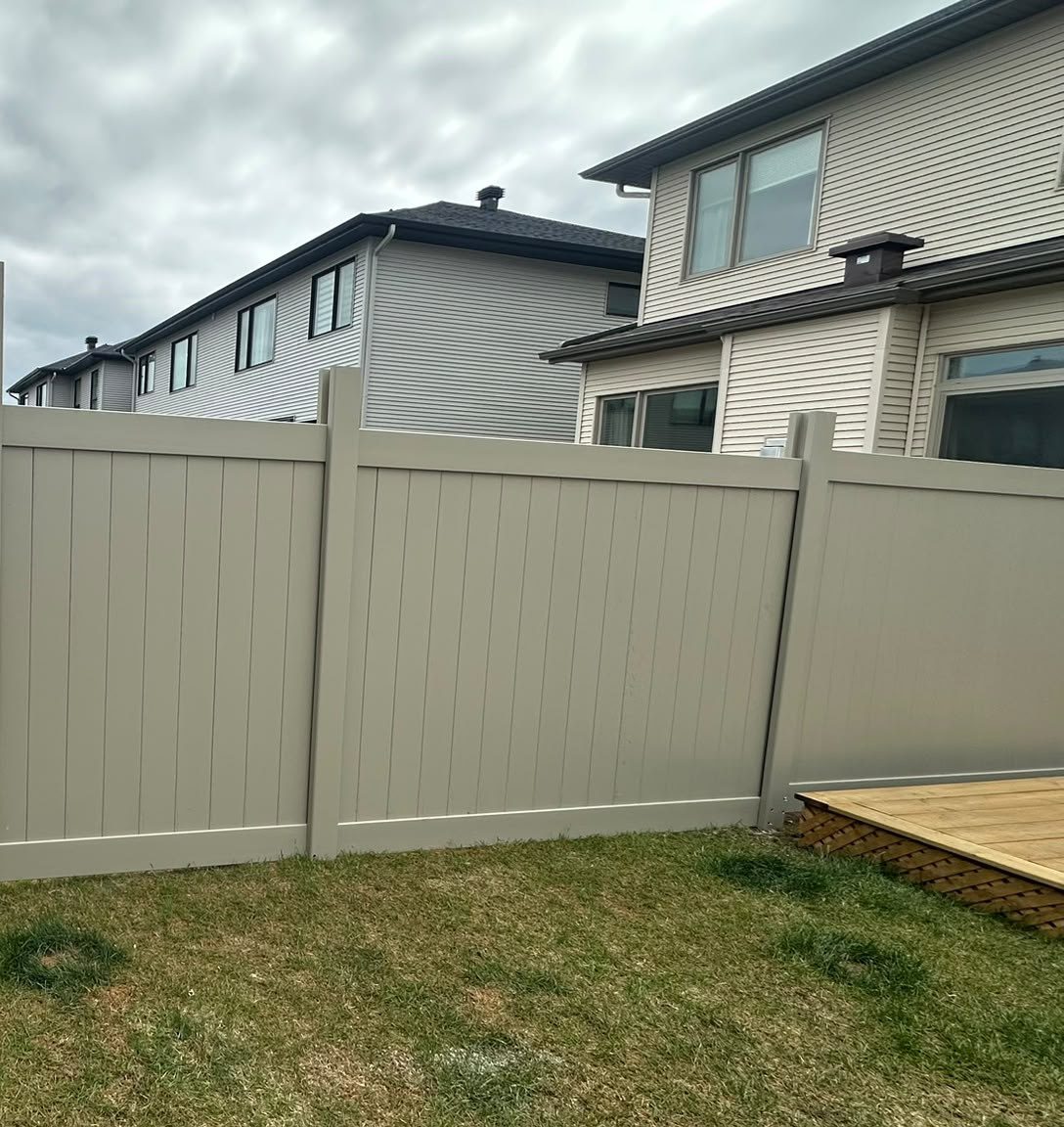 An Adobe PVC fence meeting a newly built wooden deck at the corner of a back garden.